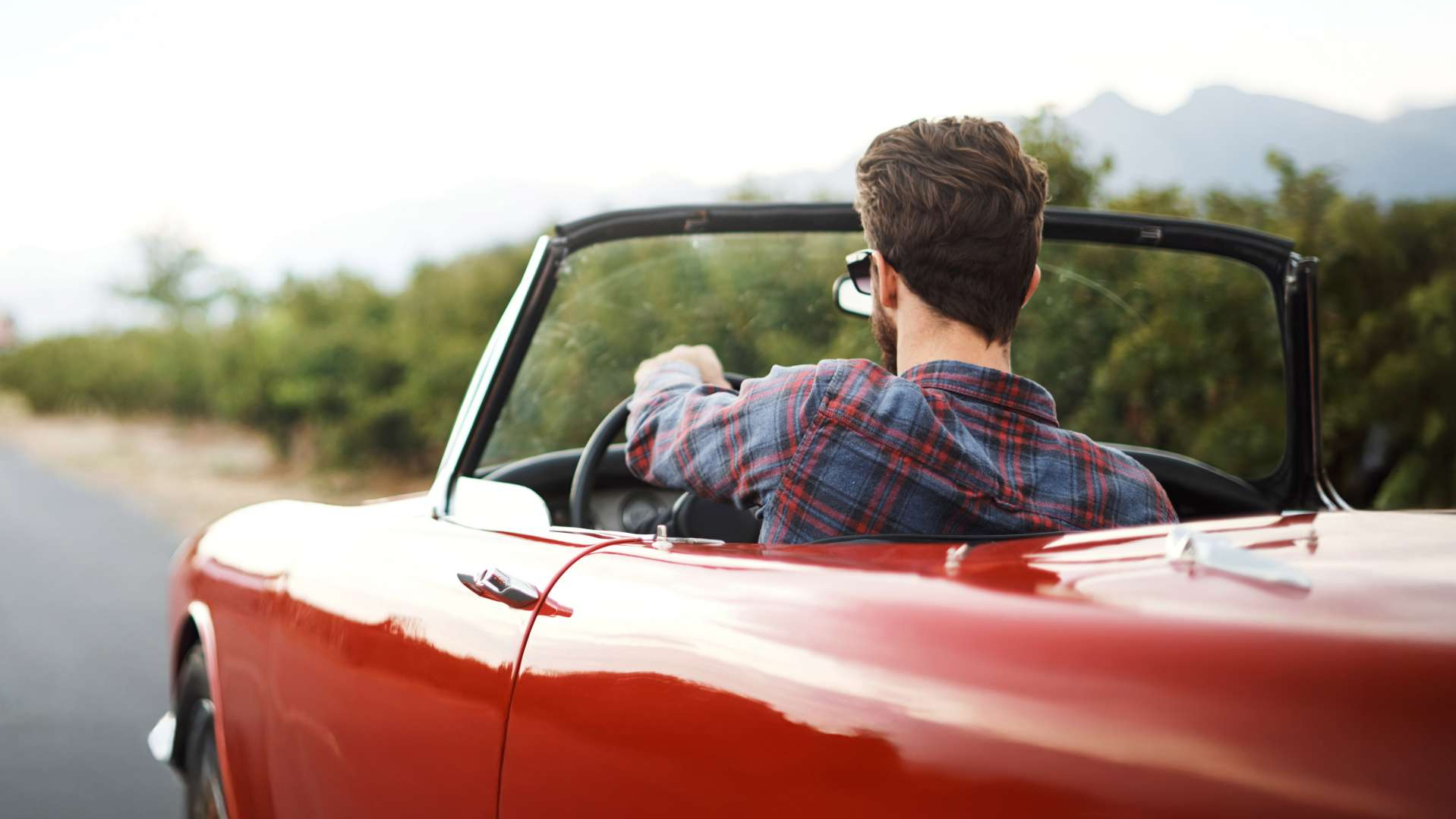 Mann am Steuer eines Oldtimer Cabriolets