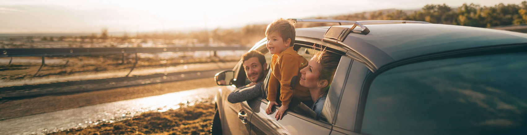 Familie sieht aus offenem Autofenster